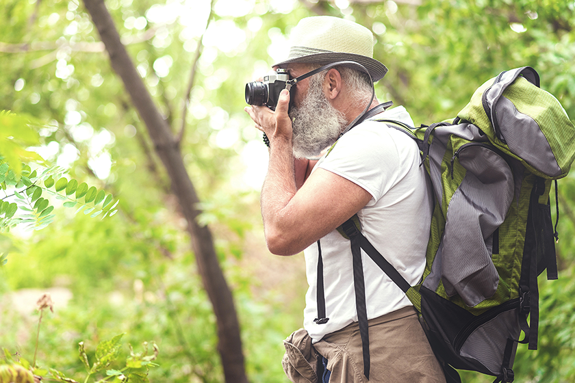 Concentrated old male tourist photographing