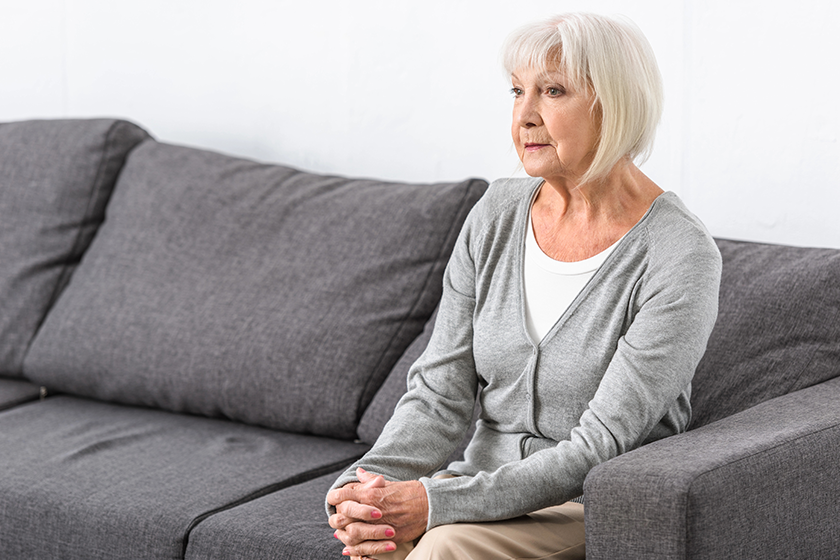 Pensive senior woman with grey hair sitting 