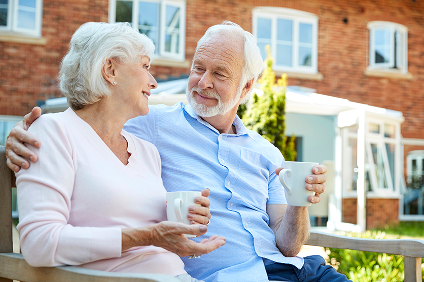 retired-couple-sitting-bench-hot-drink-assisted-living