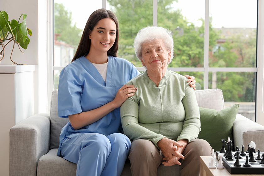 young-nurse-senior-woman-sitting-sofa-kitchen